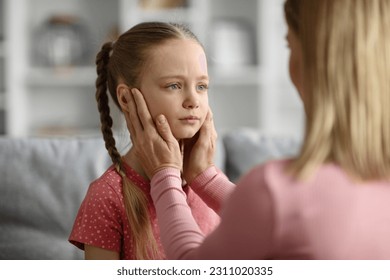 Childhood Problems Concept. Young mother comforting her sad little daughter offended after quarrel at home, caring mom calming down her child, bonding together in living room interior - Shutterstock ID 2311020335