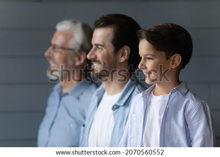 From childhood to retirement. Family dynasty of 3 different age male members stand in line together. Profiles of old age grandpa adult father and small schoolboy son grandchild look forward with smile