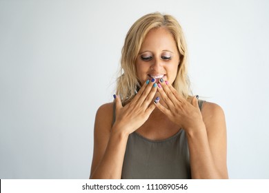 Childish Playful Blonde Lady Flirting, Feeling Embarrassed Or Awkward. Portrait Of Tanned Caucasian Woman With Colorful Nails Looking Down And Covering Chin With Fingers. Flirt Concept