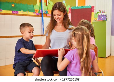 Childminder or educator reading a book for a group of children in kindergarten - Powered by Shutterstock