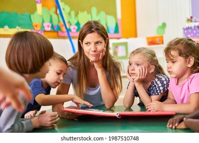 Childminder or kindergarten teacher and children read and play together in kindergarten - Powered by Shutterstock