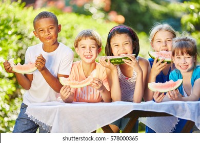 Childrean Eating Healthy Melon As Friends In Summer In Interracial Community