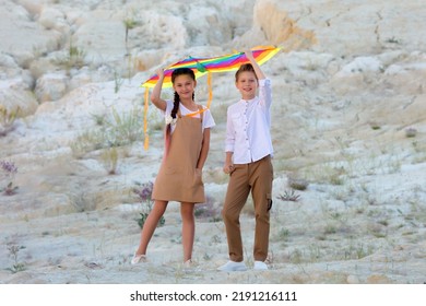 Children 8-9 Years Old Stand Under A Kite Sunset In The Mountains,