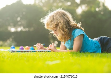 Children Artist Paints Creativity Vacation, Kids Crafts. Child Boy Painting With Paints Color And Brush In Park Outdoor.