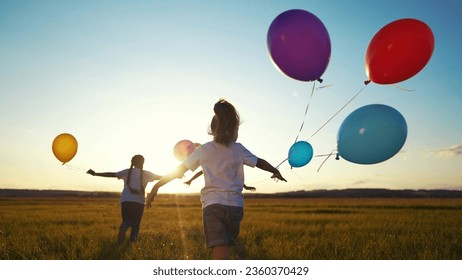 children in balloons in park. children run in nature in park with balloons. happy family kid holiday concept. children view from back silhouette run in nature at dream sunset holding balloons - Powered by Shutterstock