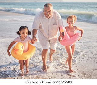 Children, Beach And Family With A Girl, Grandfather And Sister Playing On The Sand By The Sea Or Ocean In Summer. Water, Travel And Fun With A Grandparent, Grandchild And Sibling Outdoor On Holiday