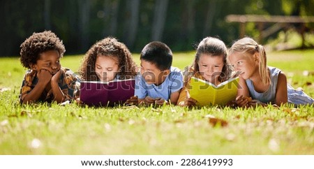 Children, books and lying in park with friends, learning or diversity for reading at school playground. Kids, education or study with support, mockup space or solidarity at multicultural kindergarten