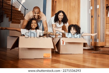 Children in boxes while moving into a new home with their parents playing in a silly, goofy and fun mood. Happy, smile and family being playful together in their modern house, apartment or property.
