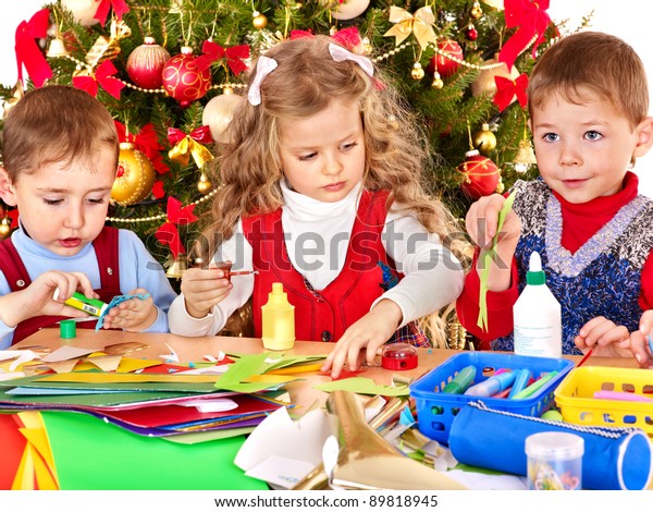 Niños y niñas haciendo decoración para Navidad.