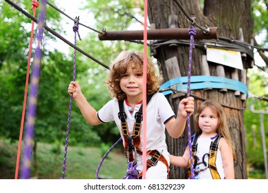 Children - a boy and a girl pass an obstacle course in a rope park - Powered by Shutterstock