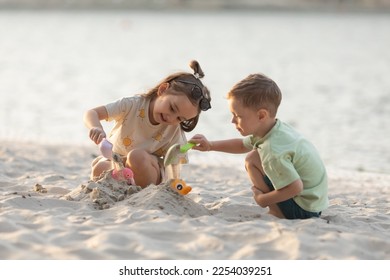 Children boy and girl playing on the beach on summer holidays. Children having fun with a sand on the seashore. Vacation concept. Happy sunny day