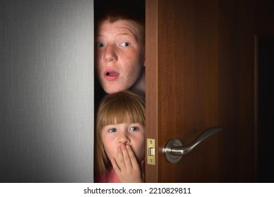 The children, a brother and a sister, peek curiously from behind the door of the room.

 - Powered by Shutterstock