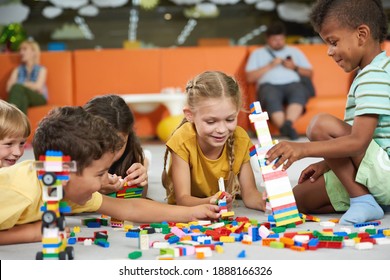 Children building blocks in kindergarten. Indoor games and activities. Kids care school.