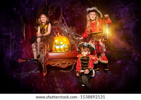 Children in carnival costumes celebrate Halloween together in an old house. Halloween party.