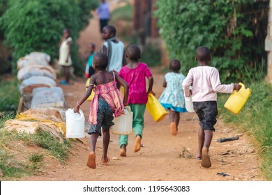 Children carrying water cans in Uganda, Africa