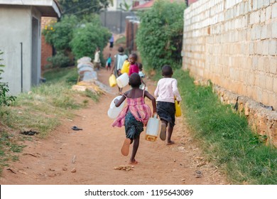 Children Carrying Water Cans In Uganda, Africa