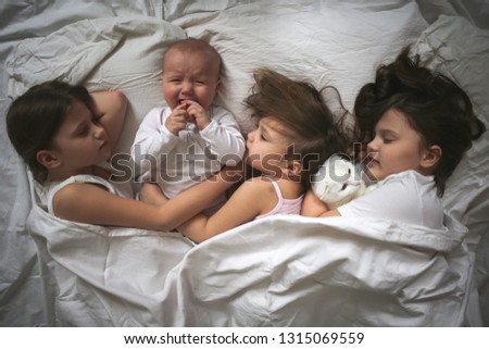 Image, Stock Photo Happy little girl holding doll and cookie while woman playing with a boy over the bed. Weekend family leisure time concept.