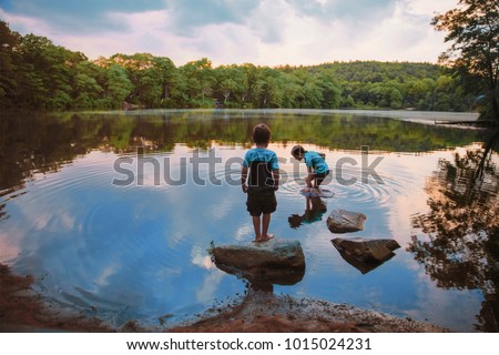children caught fish in the lake. boys playing near the water