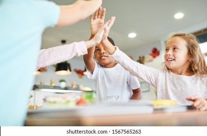 Children Celebrate Team Spirit With High Five In The Primary School Canteen