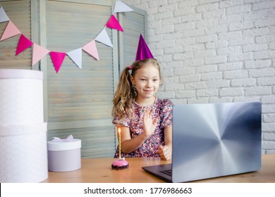 Children Celebrating Her Birthday Through Video Call Virtual Party With Friends. Lits Out Candle. Coronavirus Outbreak 2020. Birthday Party With Cake Online Together With Her Friend.