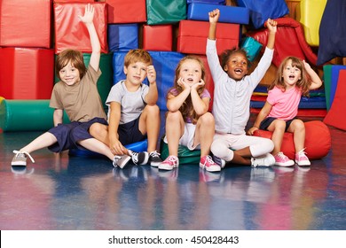 Children cheering together after victory in gym of a pre school