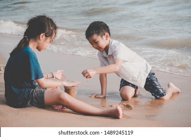 Children Is Cleaning Up Garbage On The Beach For Enviromental Clean Up Concept