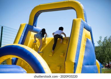 Children climb an inflatable slide. Inflatable obstacle course for fun. Active rest for children. Inflatable playground. Sports and fun. - Powered by Shutterstock