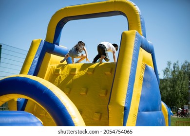 Children climb an inflatable slide. Inflatable obstacle course for fun. Active rest for children. Inflatable playground. Sports and fun. - Powered by Shutterstock