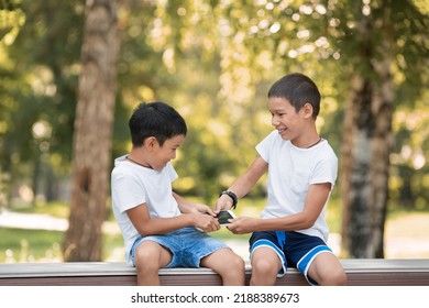 Children Conflict. Two 10 Years Old Boys, Brothers, Arguing Over A Digital Tablet, Outdoor In Public Park In Summer, Selective Focus. PC Game, Rivalry, Child Psychology, Relationship Concept