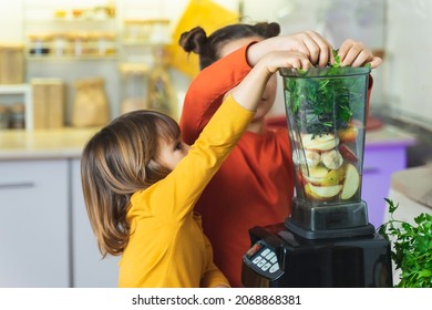 Children cook green smoothies, children cut greens: spinach, parsley, Kale and put in Blender.  - Powered by Shutterstock