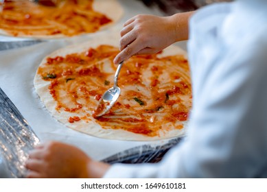 Children cook pizza. Master class from the chef in a restaurant, Close-up of children's hands roll out the dough baking bread.kids kneads the yeast dough for baking bread. fermented dough. - Powered by Shutterstock