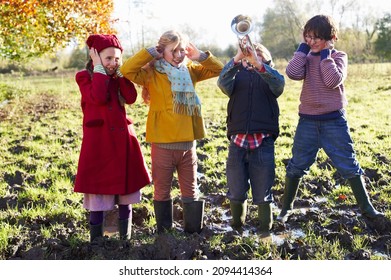 Children covering their ears as boy plays trumpet