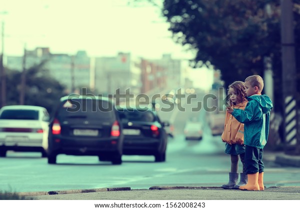 children cross the road / boy\
and girl small children in the city at the crossroads, car,\
transport