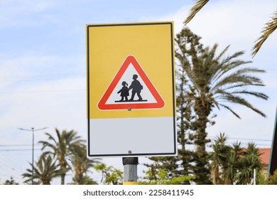 Children crossing road sign on city street, closeup