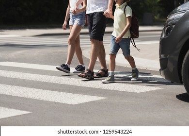 Children crossing the street with their father