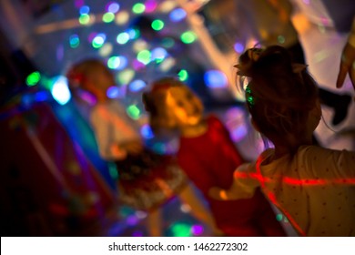 Children Dance At Christmas Party In Blue LED Lights Room. Laser And Neon Show At Child's Birthday. Happy Childhood. Animators At Children's Party. Baby Disco. Selective Focus