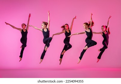 Children are dancing. A group of children, little girls in sports style clothes dancing in the studio, isolated on the background in neon light. - Powered by Shutterstock