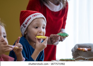 Children Decorating Christmas Biscuits And Eating Gingerbread Cookies In Kitchen Together With Mrs. Claus. Kids Cooking Class. Merry Christmas And Happy Holidays Concept