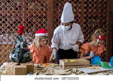 Children Decorating Christmas Biscuits And Gingerbread Cookies In Kitchen Together With Chef. Kids Cooking Class. Merry Christmas And Happy Holidays Concept