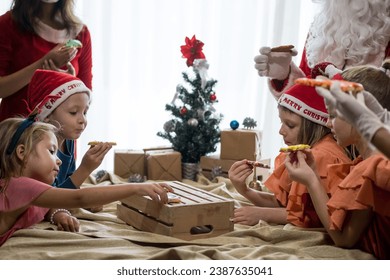 Children decorating Christmas biscuits and gingerbread cookies in kitchen together with chef, Santa Claus and Mrs. Claus. Kids cooking class. Merry Christmas and happy holidays concept - Powered by Shutterstock