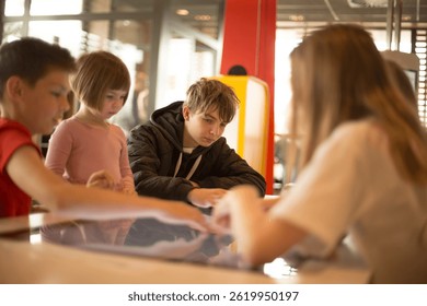 Children are deeply engaged in an interactive digital learning activity while being in a welcoming, familyfriendly environment