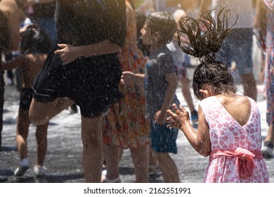 Children Of Different Ethnicities Playing In The Street With Water And Foam Thrown By Firefighters At A Local Party