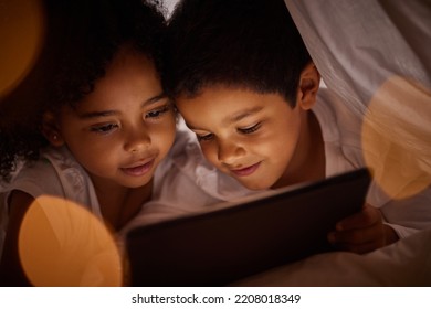 Children, Digital Tablet And Streaming Movies On Internet In Fun Blanket Fort At Home At Night. Happy, Boy And Girl Kids Playing And Enjoying Online Games Together With Subscription On Mobile Device.