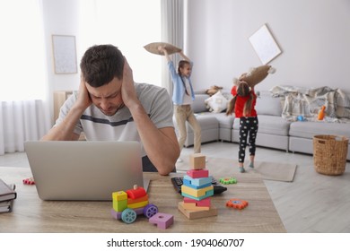 Children disturbing stressed man in living room. Working from home during quarantine