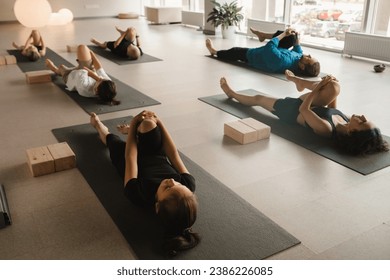 Children do yoga in the gym under the guidance of an instructor. Children's gymnastics. - Powered by Shutterstock