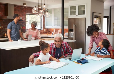 Children Doing Homework In Busy Multi Generation Family Home