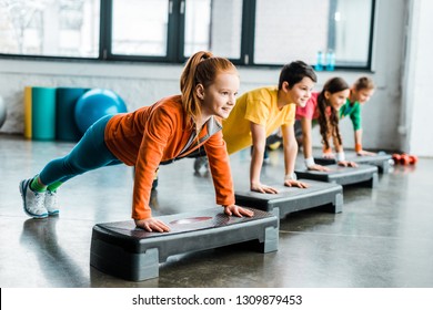 Children doing plank exercise with step platforms 