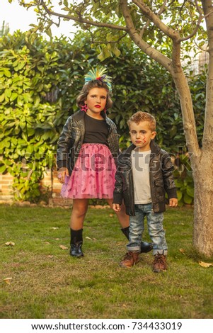 Children dressed up as rockers with leader jacket and make up. Outdoor