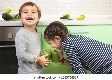 Children drink green smoothie for breakfast. Brother and sister have fun in the kitchen and drink green fresh smoothie. Healthy family concept and lifestyle. - Powered by Shutterstock