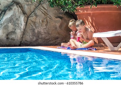 Children Drink Juice By The Pool
